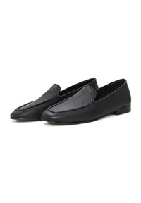 Mocasini din piele neagră au o textură netedă, o formă alungită, vârful ușor ascuțit și un design minimalist, fără hardware vizibil.