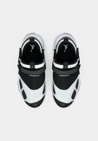 Αθλητικά παπούτσια ασπρόμαυρα με επάνω μέρος από δίχτυ, χαρακτηριστικά με υφή και έντονο λογότυπο. Ο σχεδιασμός περιλαμβάνει ασφαλή λουρί και επένδυση στο κολάρο.