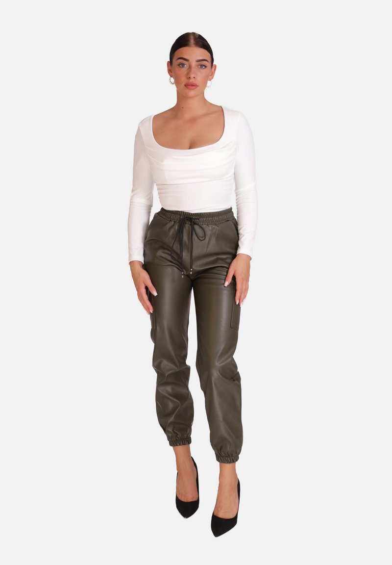 Witte long-sleeve top met vierkante halslijn, gecombineerd met olijfgroene synthetische joggingbroek met een elastische taille en zijzakken.