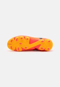 Suola di scarpa con un design testurizzato, prevalentemente arancione brillante con dettagli rosa. Presenta borchie per la trazione e una costruzione a strati.