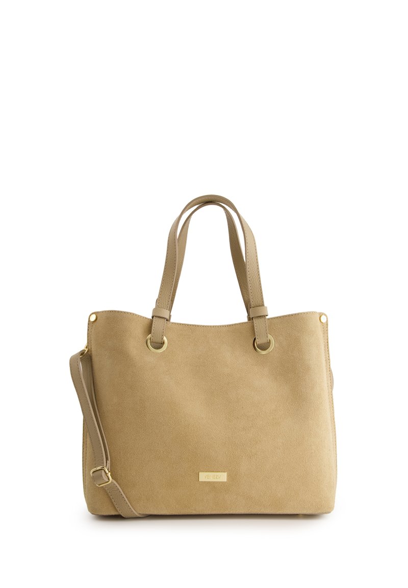 Beżowa skórzana torebka z dwoma uchwytami na górze i odpinanym paskiem na ramię. Posiada złote akcesoria i logo marki z przodu.