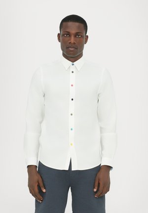 Hvid langærmet skjorte med knaplukning fortil, der har multicolor knapper. Glat, let stof med klassisk krave og manchetter.