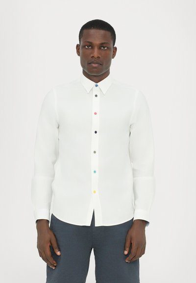 Hvid langærmet skjorte med knaplukning fortil, der har multicolor knapper. Glat, let stof med klassisk krave og manchetter.