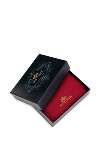 Black box with ornate blue design and gold "WITTCHEN" logo, containing a red fabric item with a serrated edge.