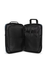 Open black travel organizer with multiple zippered compartments, handle on top, and elastic strap on the right side pocket.
