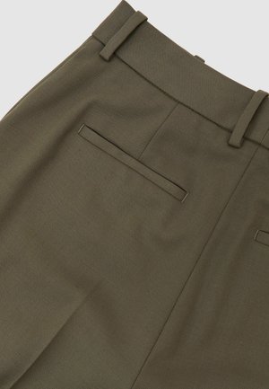 Alyvuogių žalios kelnės su tekstūruota medžiaga, turinčios lygų priekinį paviršių, diržo kilpas ir vieną galinę kišenę su siūtu užsegimu.