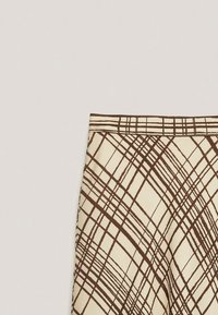 Beige skirt featuring a geometric brown plaid pattern, with a flat waistband and smooth, textured fabric.