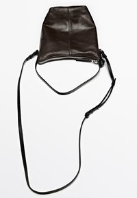 Sac en cuir brun foncé à bandoulière avec fermeture éclair argentée et longue sangle noire réglable sur fond blanc.
