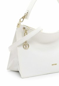 Borsa a mano in pelle bianca con finitura testurizzata, accessori in oro e tracolla rimovibile. Presenta un logo prominente e una forma angolare.