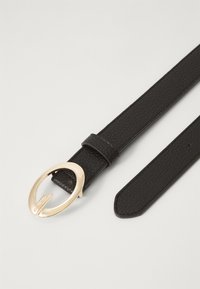 Black leather belt featuring a circular golden buckle, textured surface, and a simple design. Includes a loop and adjustable length.