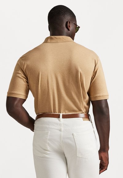 Τα πανέμπορκα πόλο μπλουζάκι με κοντά μανίκια, λεία υφή και κλασικό γιακά, συνδυασμένο με άσπρο παντελόνι και καφέ ζώνη.