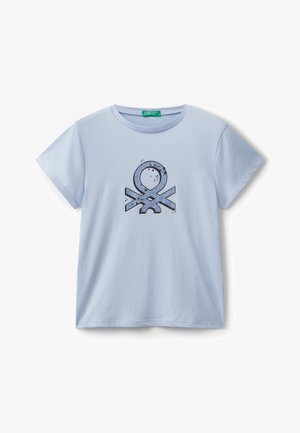 Světle modré bavlněné tričko s krátkým rukávem a kulatým výstřihem. Uprostřed je tmavý grafický design se skvrnitými akcenty.