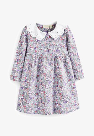 Robe fleurie à manches longues, col en broderie anglaise blanche, sur un fond violet. Comprend de petites fleurs rose, violettes et vertes sur le tissu.