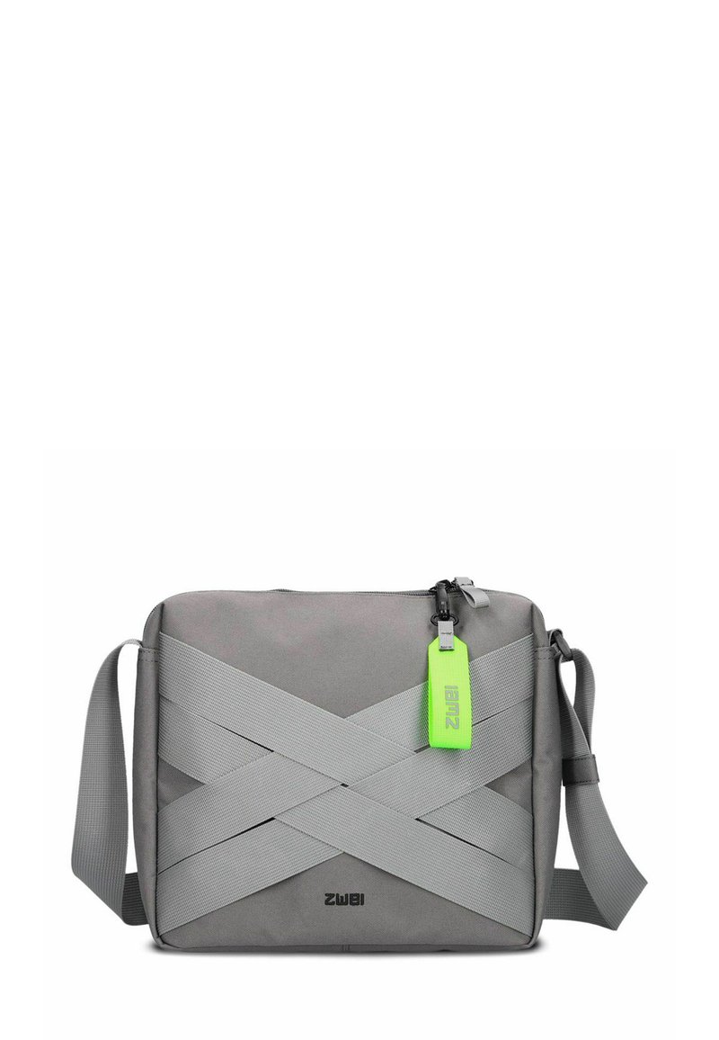 Grau Crossbody-Tasche aus strapazierfähigem Stoff, mit breiten elastischen Bändern auf der Vorderseite, einem Vorderreißverschluss und einem leuchtend grünen Etikett.