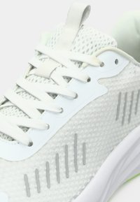 Herrensportschuh mit einem hellgrauen Mesh-Obermaterial, weißen Schnürsenkeln, Gummiapplikationen und einer strukturierten Sohle mit grünen Details.