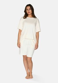Krátky rukáv, smotanový loungewear set s ribovanou textúrou, voľným strihom a šortkami s elastickým pásom. Ľahký a pohodlný dizajn.