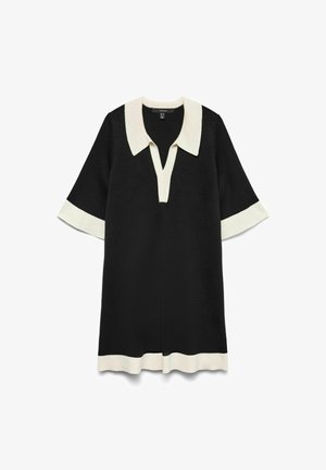 Czarna sukienka z białym kołnierzykiem i mankietami, z dekoltem w kształcie litery V, krótkimi rękawami i prostym krojem. Miękka, dzianinowa tekstura materiału.