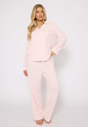 Light pink pajama set featuring a button-up top with long sleeves and a chest pocket, paired with loose-fitting pants, made of soft fabric.