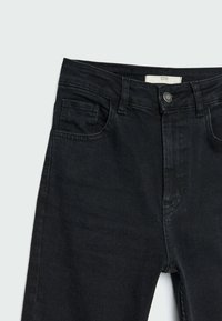 Jean denim noir avec un design classique à cinq poches, fermeture à bouton, et une texture légèrement visible dans le tissu. Aucune motif ou accent présent.