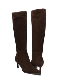 Botas de ante marrón hasta la rodilla con punta afilada y tacón de aguja. Presentan una textura suave y un diseño elegante y ajustado.