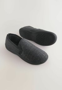 Pantof gri, din material texturat, cu talpă din cauciuc negru, prezentând un model subtil de carouri și un design cu vârf rotunjit.