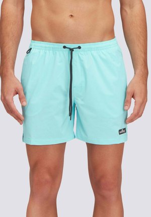 Torace e gambe maschili che indossano pantaloncini da bagno azzurri con coulisse nera e piccolo logo nero sulla gamba sinistra.
