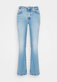 Jean en denim délavé bleu clair avec taille haute, cinq poches et jambes légèrement évasées sur un fond blanc.