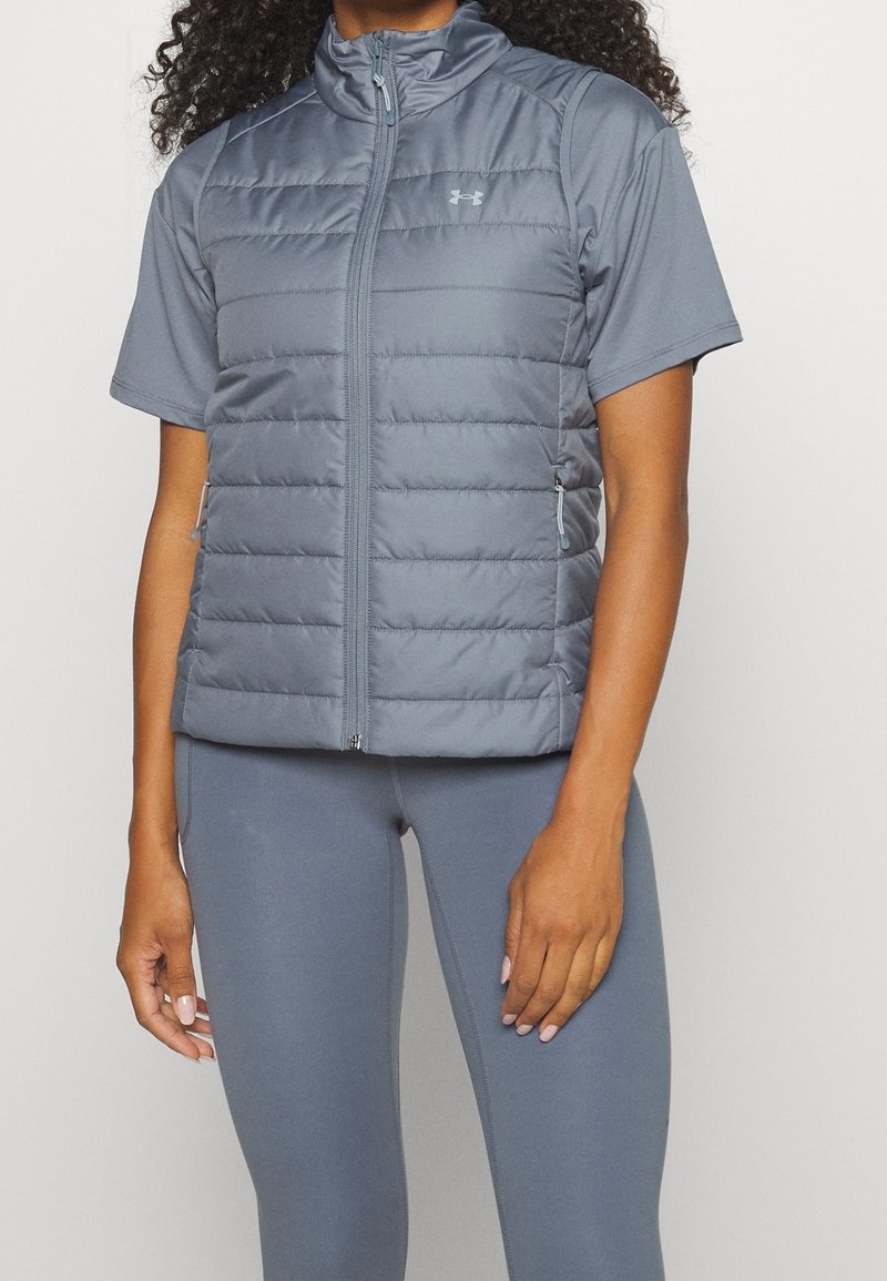 Lightweight gray puffer vest with short sleeves, front zipper, and subtle stitching; paired with matching gray leggings.