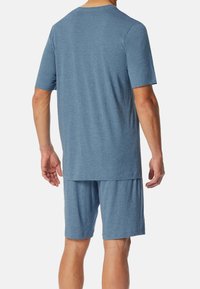 Blaues Kurzarmhemd und passende Shorts aus weichem Stoff. Das Hemd hat einen runden Ausschnitt; die Shorts verfügen über einen elastischen Bund.