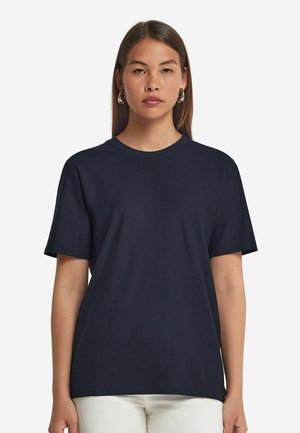 Marineblaue BaumwollT-Shirt mit lockerer Passform, kurzen Ärmeln, rundem Halsausschnitt und subtiler Textur. Keine sichtbaren Logos oder Muster.