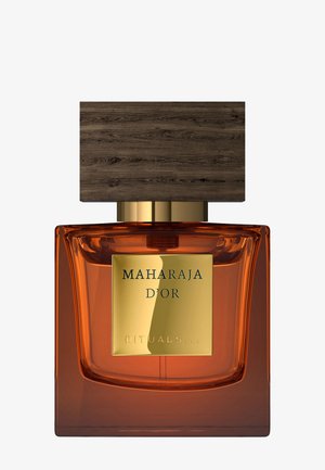 Flacon de parfum carré en verre ambré avec grand bouchon en bois foncé et étiquette dorée portant l'inscription Maharaja D'Or Rituals.