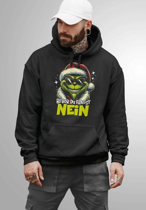 Black hoodie featuring a graphic of a green character with sunglasses and a Santa hat. Text reads "Bevor Du Fragst NEIN." Front pocket.