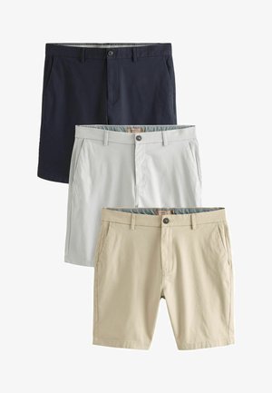 Tres pares de pantalones cortos: azul marino, gris claro y beige, todos hechos de una tela suave, con bolsillos frontales y cierres de botón.