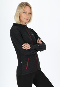 Black zip-up jacket with red accents, made of textured fabric. Features a hood, zip pockets, and a slim fit design.