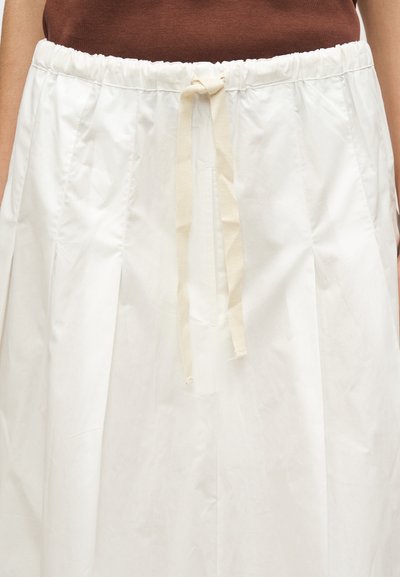 Άσπρη πλισέ φούστα με ελαστική μέση και μπεζ κορδόνι. Κατασκευασμένη από ελαφρύ ύφασμα, διαθέτει λεία υφή και μινιμαλιστικό σχεδιασμό.