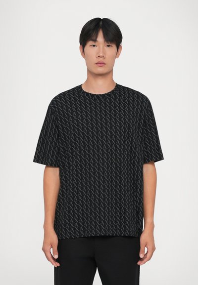 T-shirt noir à manches courtes présentant un motif répétitif de formes géométriques grises. Encolure ronde et coupe décontractée, fabriqué en tissu doux.