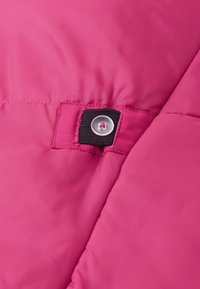 Roosa isoleeritud jakikangas läikiva viimistlusega, musta rihma ja läbipaistva nupuga detailiga kinnituses.