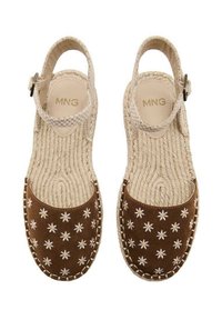 Sandales en toile marron avec broderie florale blanche, bride en tresse autour de la cheville et semelles en jute tressé pour une texture et un confort optimaux.