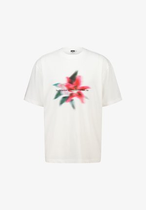 T-shirt bianco in cotone con un design sfocato di fiori rosa, foglie verdi e testo nero che recita "Il Giardino Botanico, Central Park, NY."