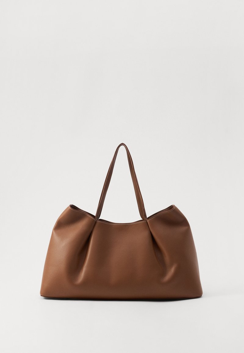 Borsa a tote in pelle marrone con un design morbido e curvo, caratterizzata da una texture plissè e due manici robusti. Accenti di cucitura minimalista.