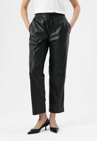 Zwarte nepleren broek met een elastische tailleband, koorddetail en zijzakken. Korte lengte met een gladde, glanzende textuur.