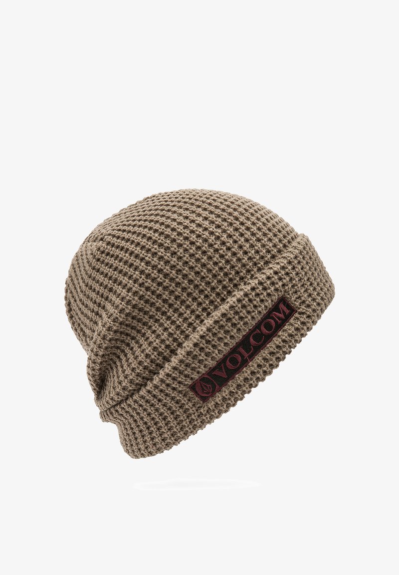 Beanie neulottu waffle-kudoksella ruskeana, jossa käännetty reuna ja burgundinvärinen logopatch, jossa on brändin nimi "VOLCOM". Valmistettu pehmeästä, teksturoidusta materiaalista.