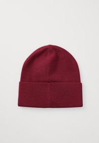 Burgundy knit beanie with a rolled cuff, smooth texture, and seamless top, suitable for casual wear in cooler weather.