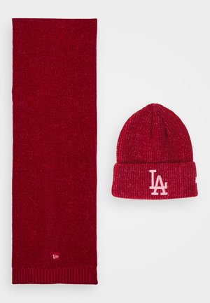 Bufanda de punto roja y gorro a juego con puño doblado, con el logo blanco "LA" en el puño del gorro.
