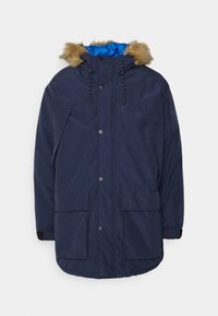 Mörkblå parkas med foder i konstgjord päls, tryckknapstängning, två framfickor och kontrasterande blå innertyg. Lämplig för kallt väder.