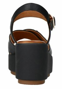 Zwarte leren sandalen met hak, voorzien van een brede band, verstelbare gesp en een dikke zwarte platformzool; bruine interieurdetails zijn zichtbaar.