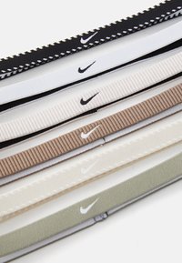 Nike gumice za kosu u crnoj, bijeloj, bež i zelenoj boji. Svaka ima rebrastu teksturu s detaljem loga, raspoređene horizontalno.