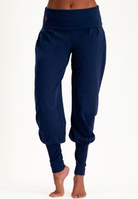 Marineblaue Lounge-Hosen mit einem breiten Bund, gerafften Bündchen und weichem Stoff. Mit kleinen bestickten Details am Bund.