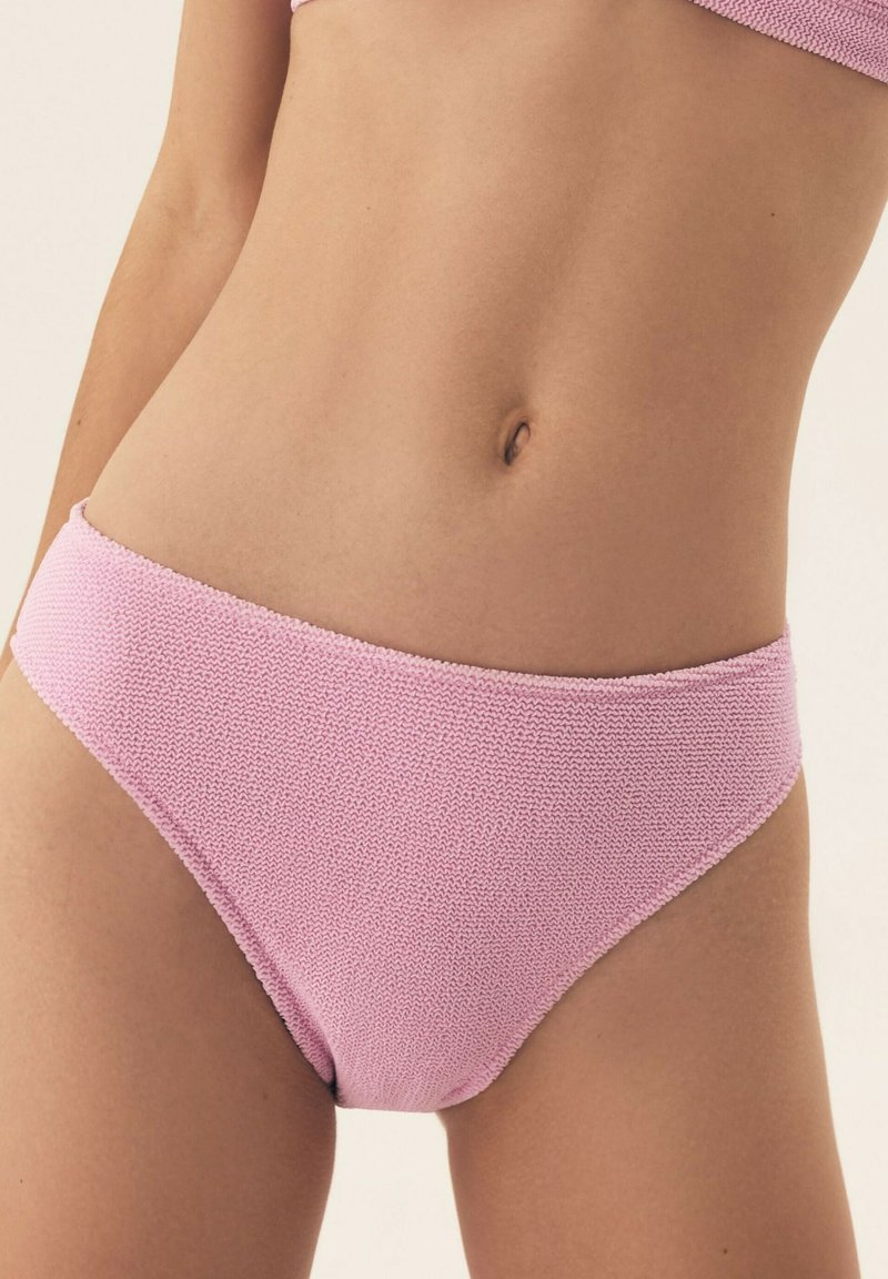 Różowy, dziany dół bikini o gładkiej fakturze, z klasycznym krojem na średnim wysokości i standardowymi otworami na nogi. Prosty design bez dodatkowych ozdób.