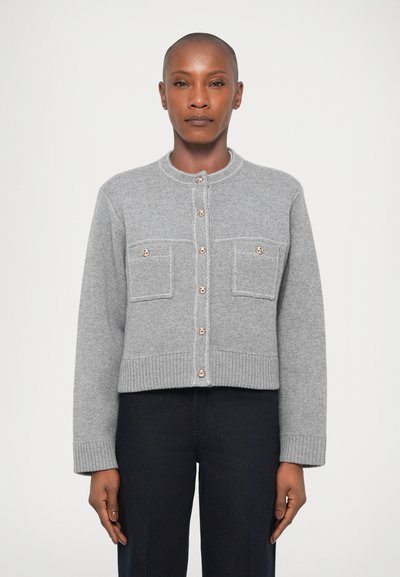 Gray cropped cardigan made of soft material, featuring a round neckline, two front pockets, and gold-tone buttons along the front.